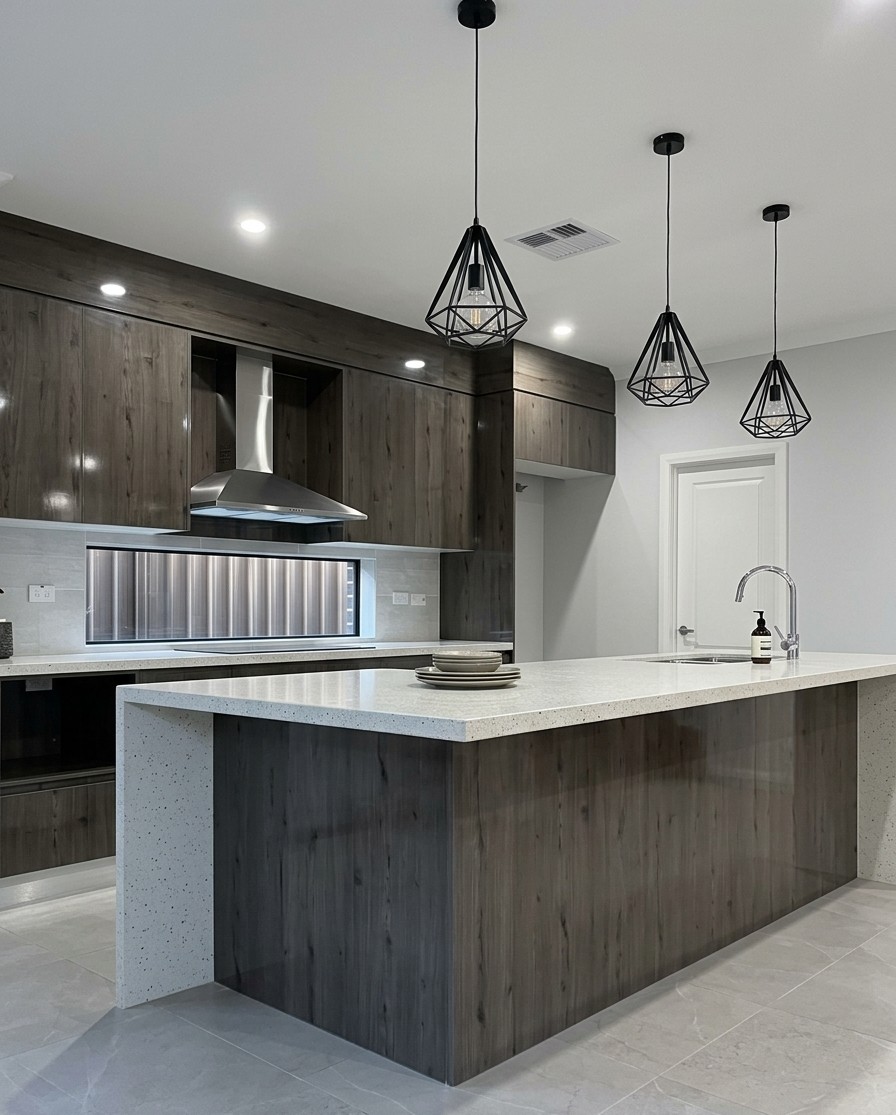 A kitchen with timber cabinetry and pendant lighting in an Elegant Homes NSW build